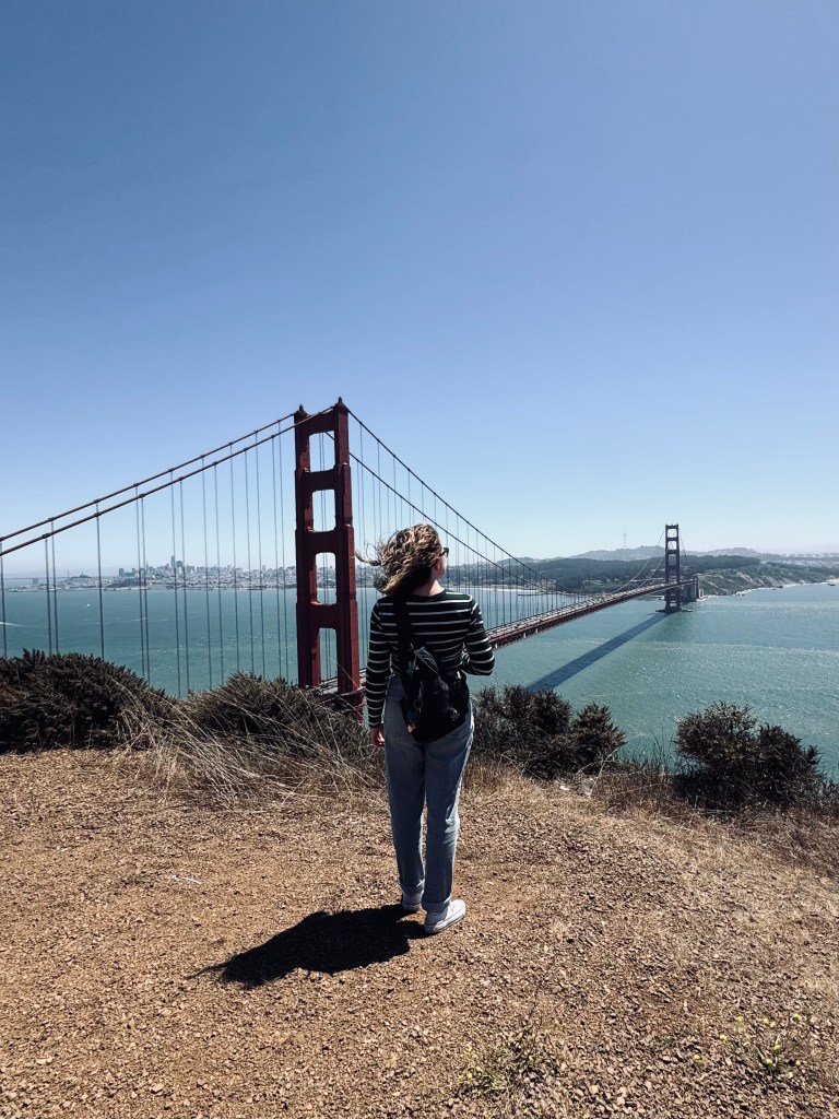 Girl looking out at Golden Gate Bridge on a sunny clear day in San Fransisco, USA