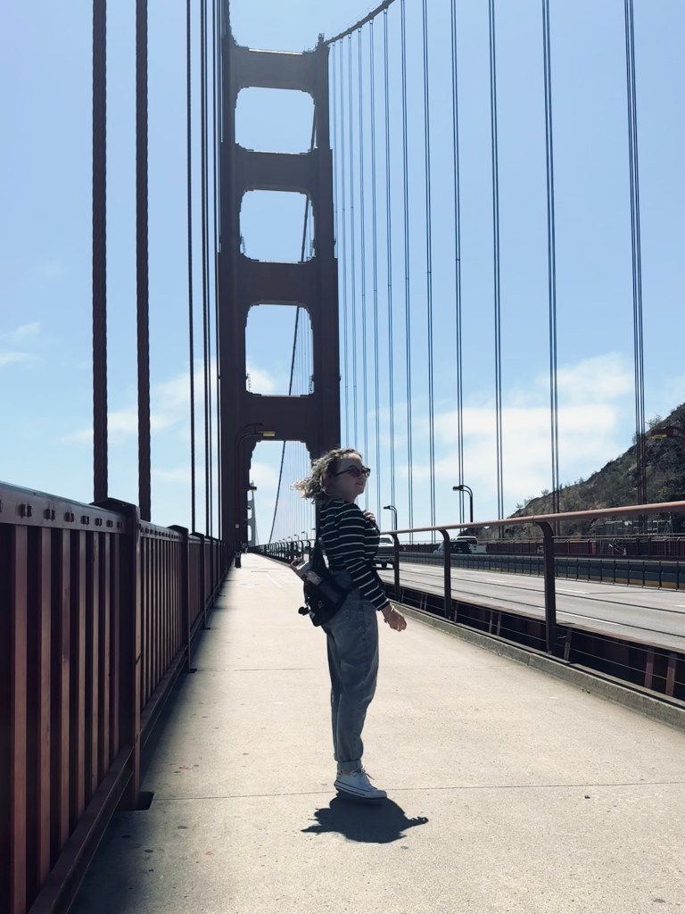 Girl walking across Golden Gate Bridge on a sunny clear day in San Fransisco, USA