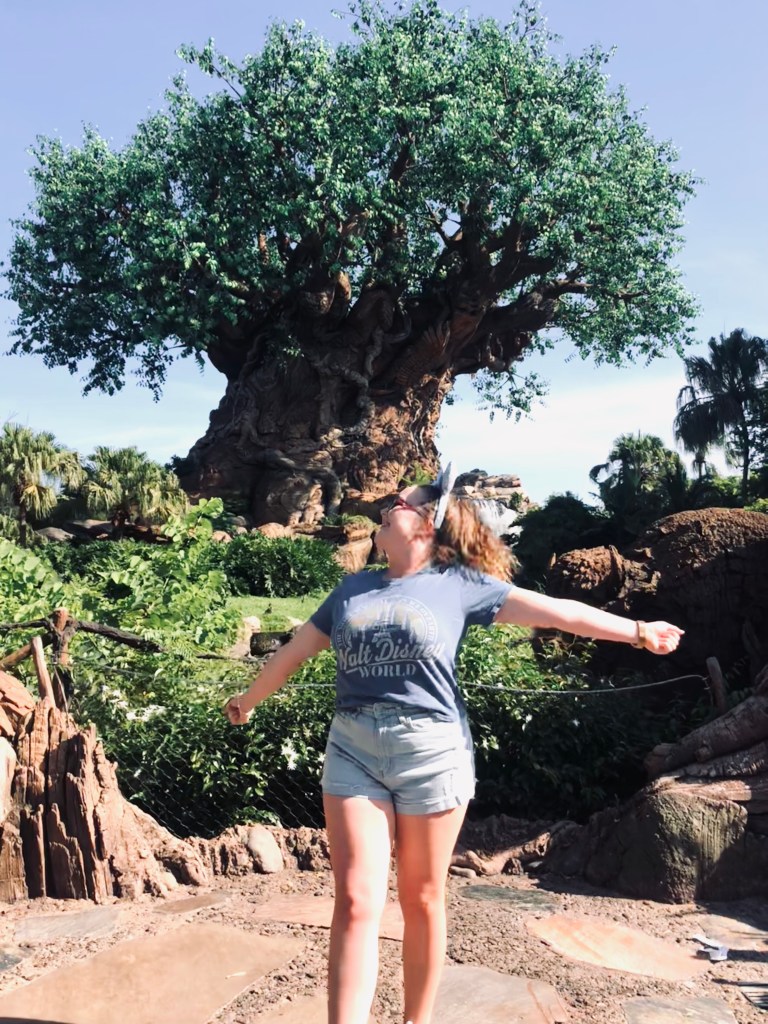 Girl wearing minnie mouse ears looking back at Tree of Life at Disney's Animal Kingdom theme park