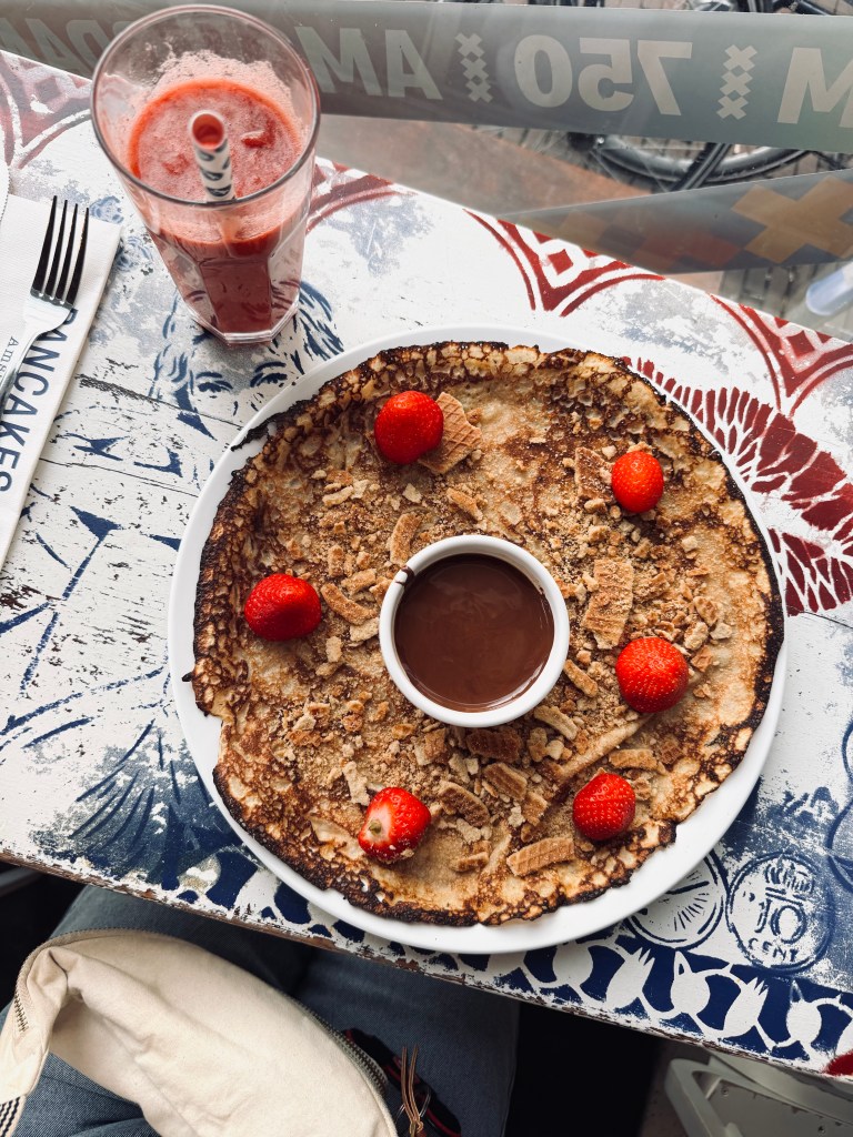 Dutch pancake with strawberries and crushed stroopwafel pieces in Amsterdam, The Netherlands