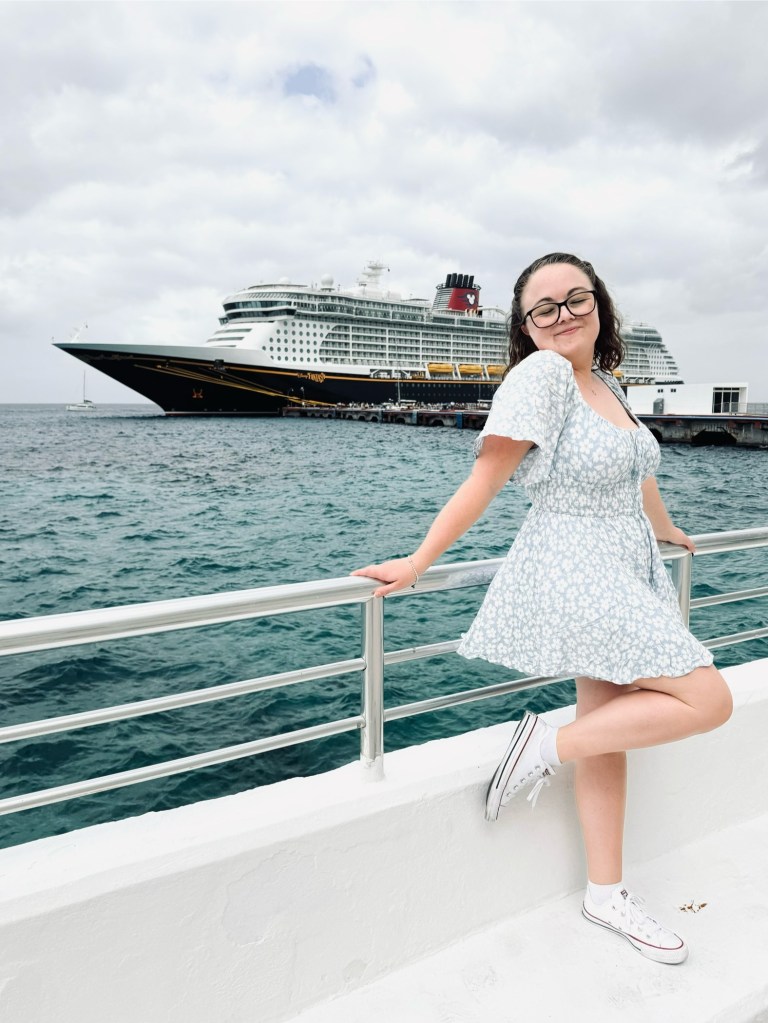 Girl in dress smiling in front of disney cruise ship in cozumel, mexico