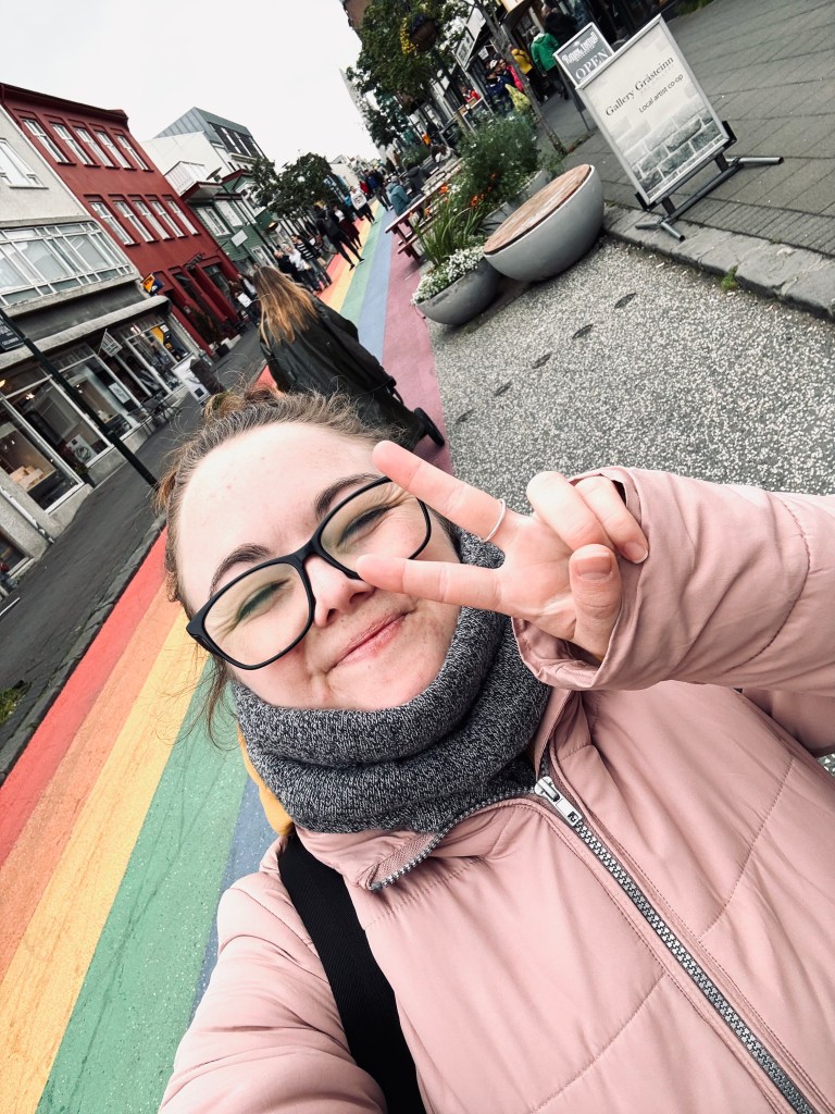 Girl taking selfie on rainbow road in Reykjavik, Iceland