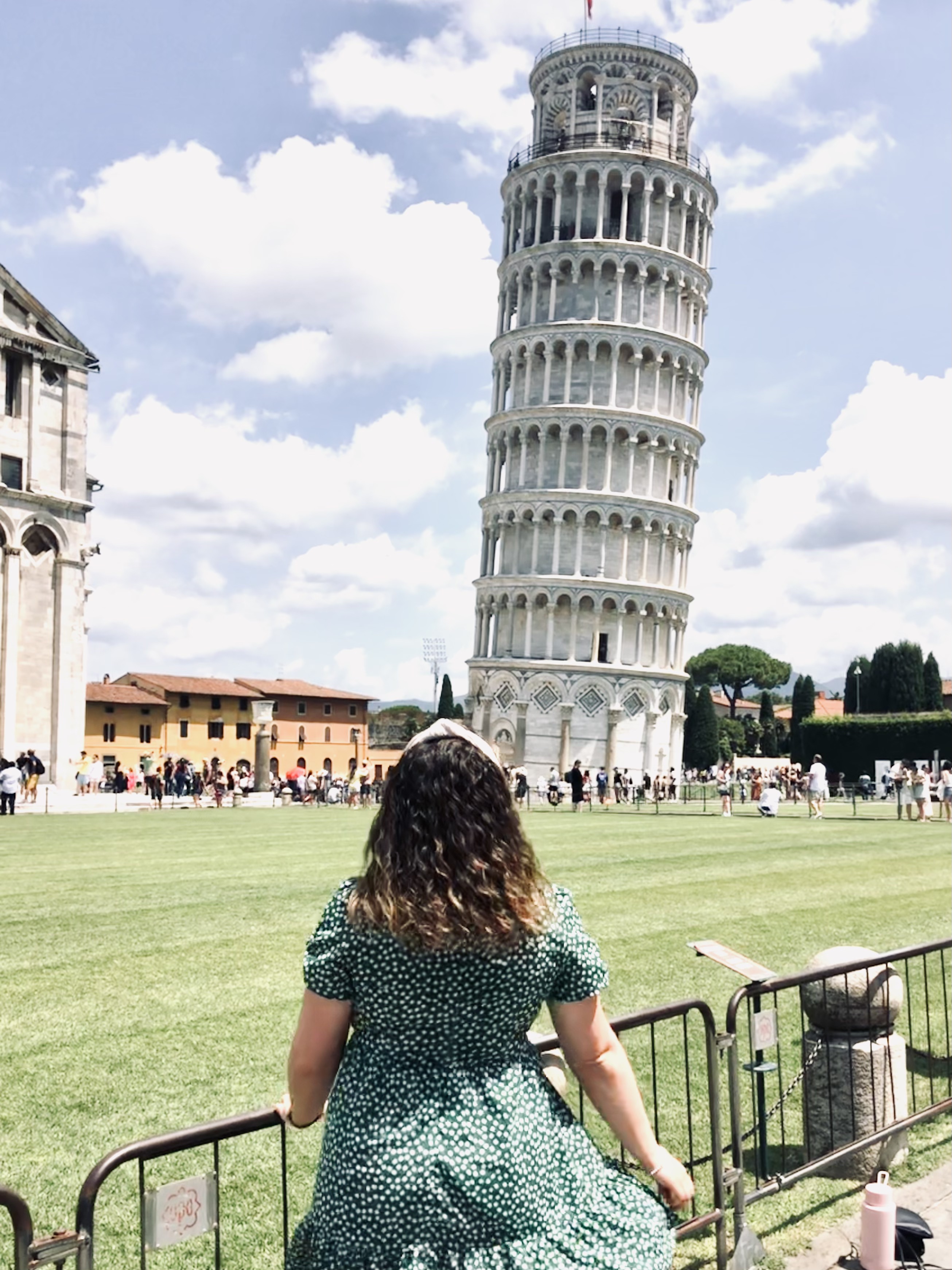 Girl looking out at leaning tower of Pisa in Italy