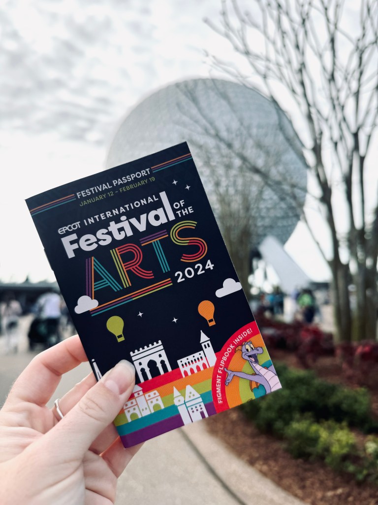 Hand holding festival of the arts booklet at EPCOT