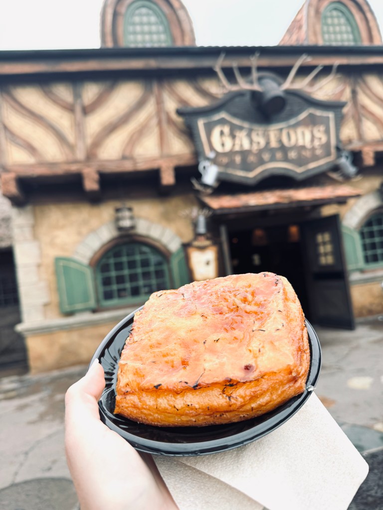 Hand holding creme brulee pastry at Gaston's Tavern in Magic Kingdom, Walt Disney World