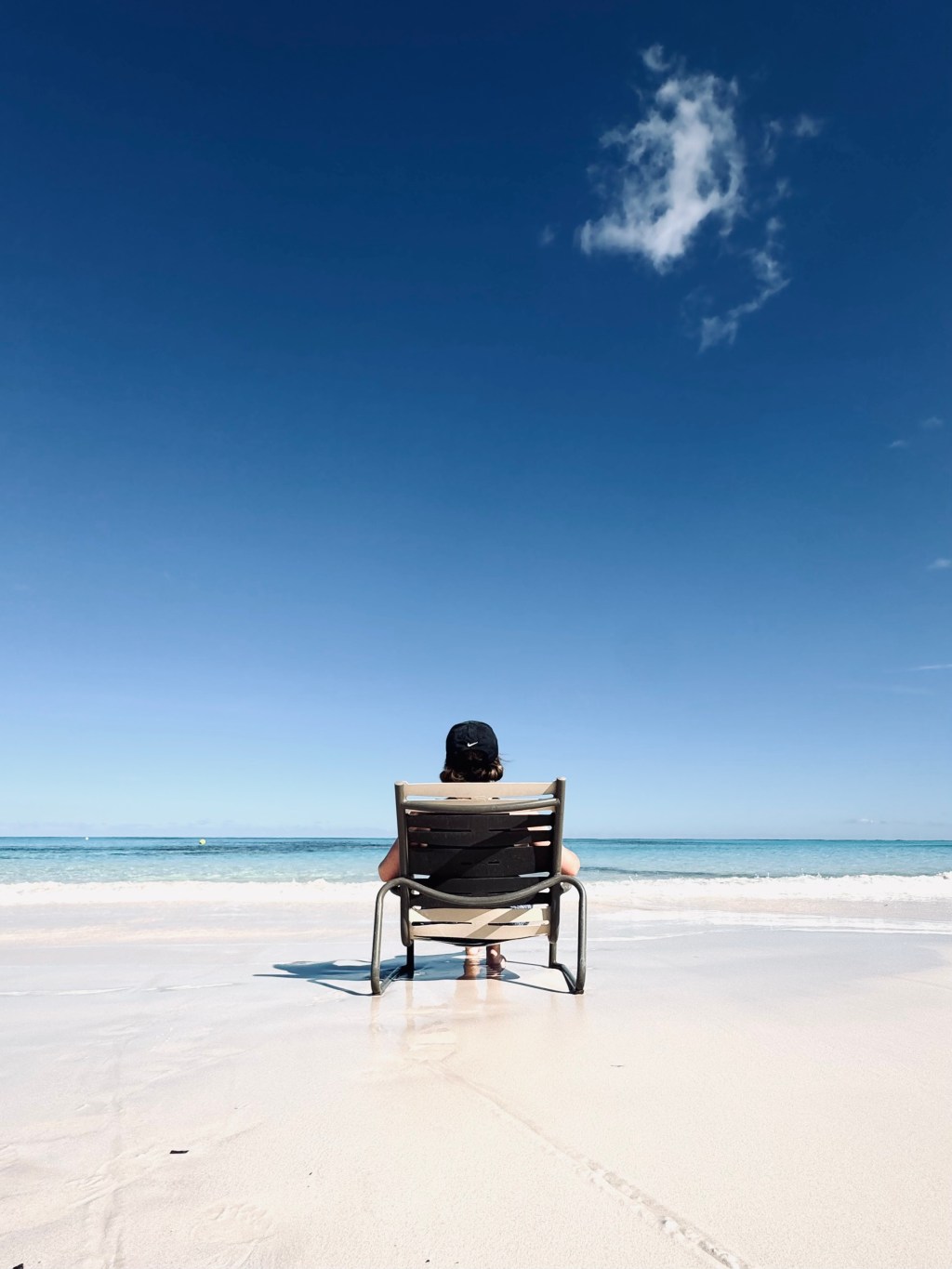 Girl sitting on deck chair at Disney Lookout Cay at Lighthouse point in the Bahamas