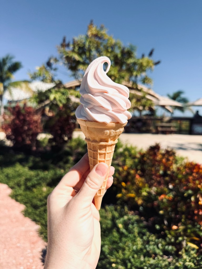 Hand holding strawberry soft serve ice cream at Lookout Cay at Lighthouse Point on a Disney Cruise in the Bahamas
