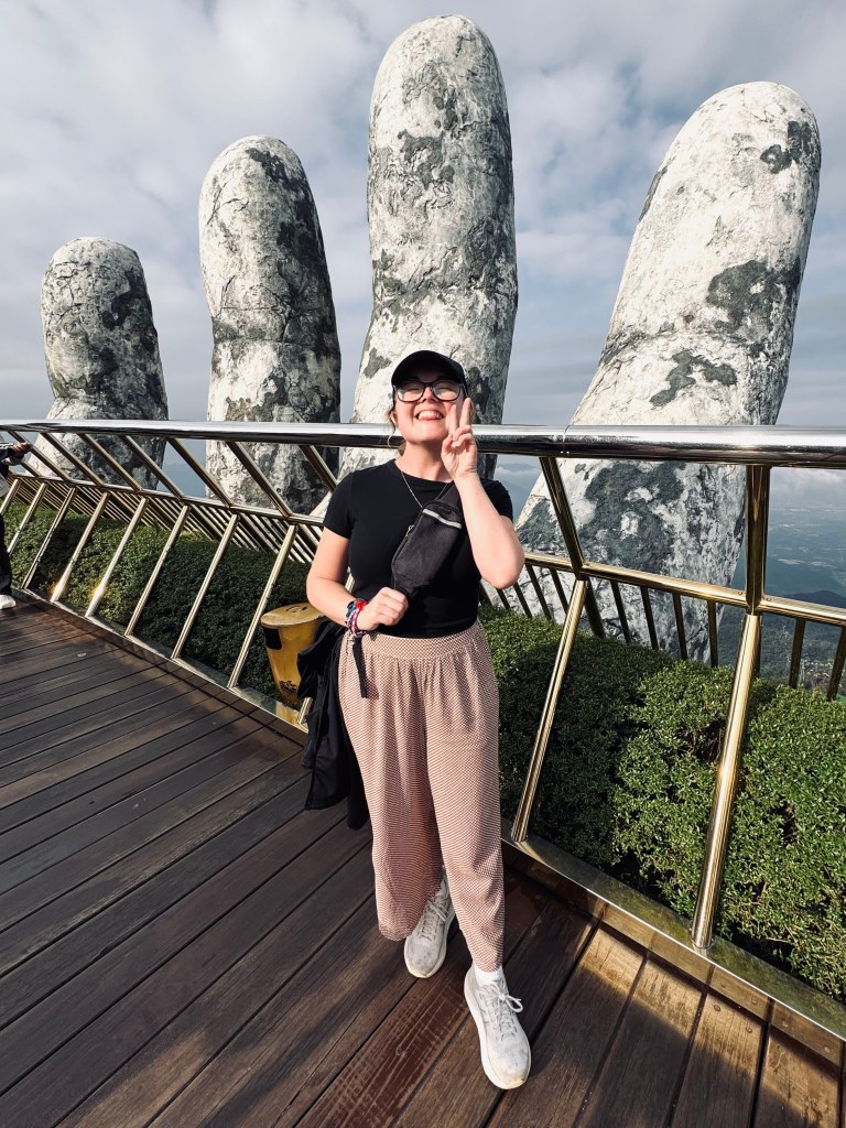 Girl smiling at Golden Bridge giant hands at Ba Na Hills, Vietnam