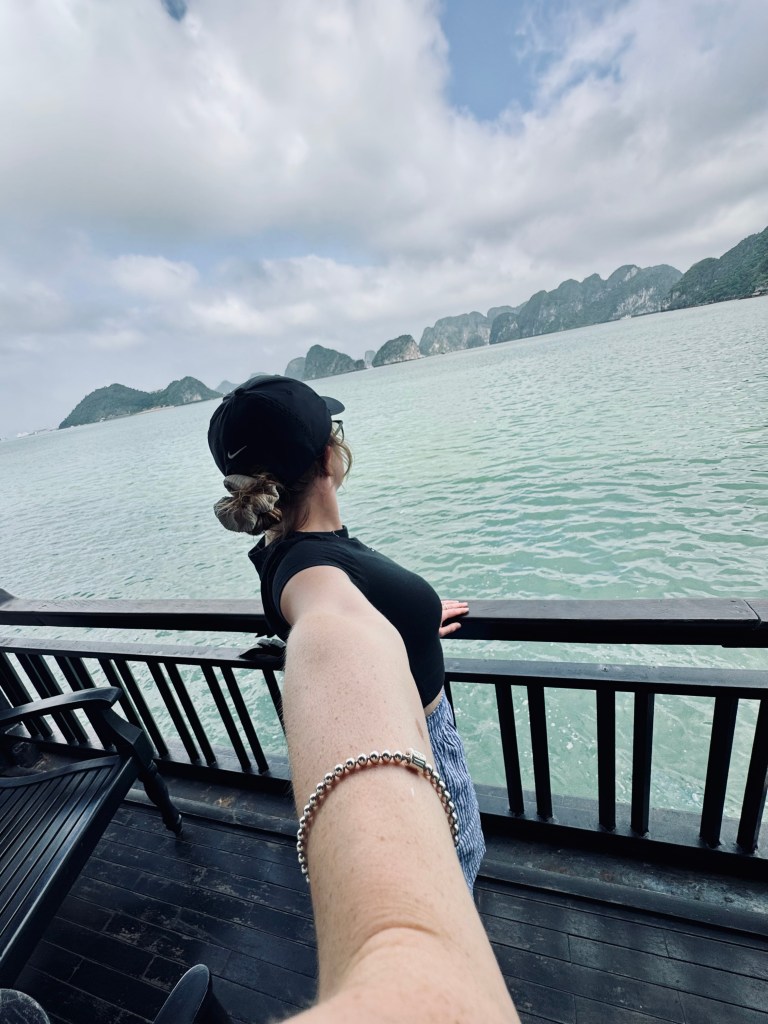 Girl taking selfie on balcony on a Halong Bay cruise, Vietnam