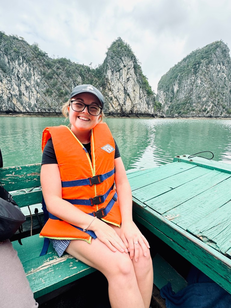 Girl in life jacket smiling on a bamboo boat on a Halong Bay cruise, Vietnam