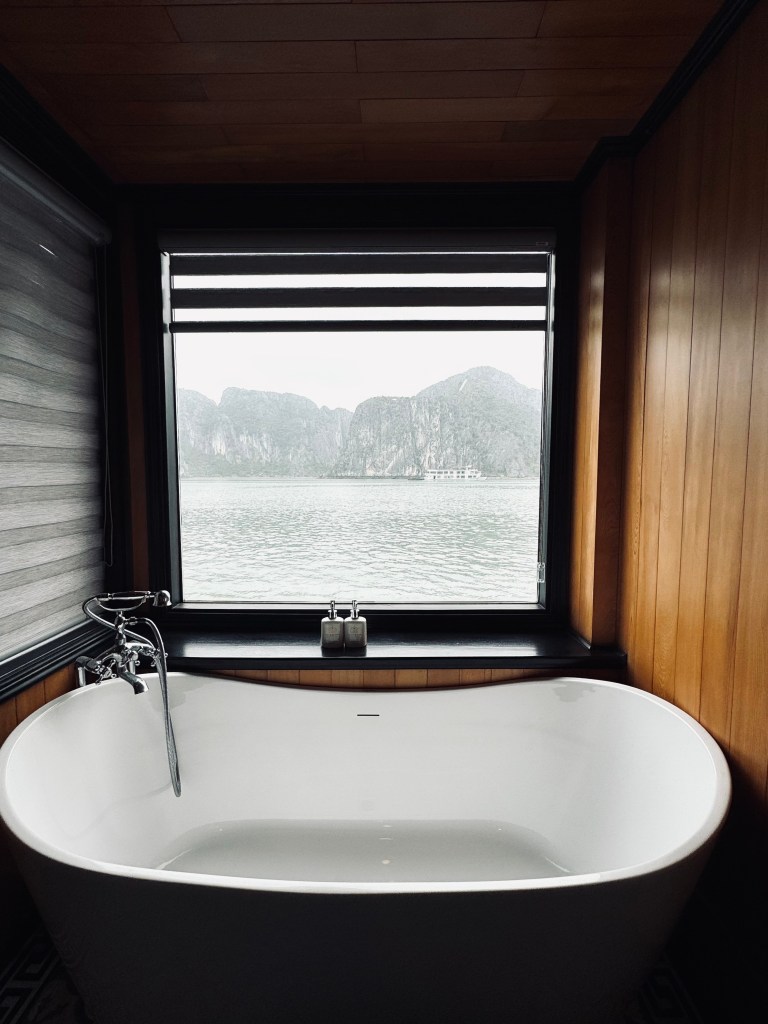 Big bathtub with views of limestone cliffs through window on a Halong Bay cruise, Vietnam