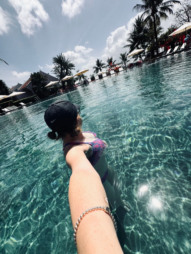 Girl taking selfie in the pool of a resort of Hoi An, Vietnam