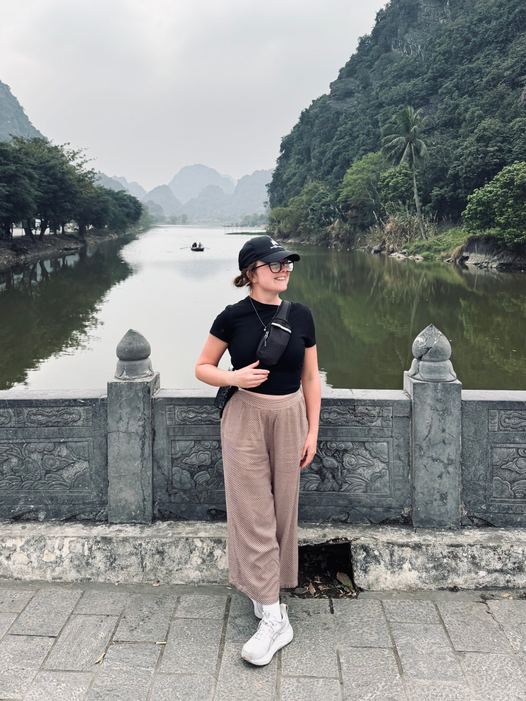 Girl posing in front of green river with green mountains in Ninh Binh, Vietnam