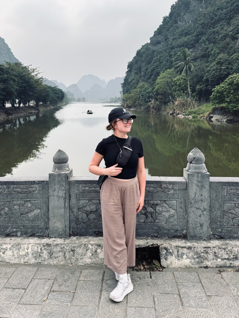 Girl posing in front of green river with green mountains in Ninh Binh, Vietnam