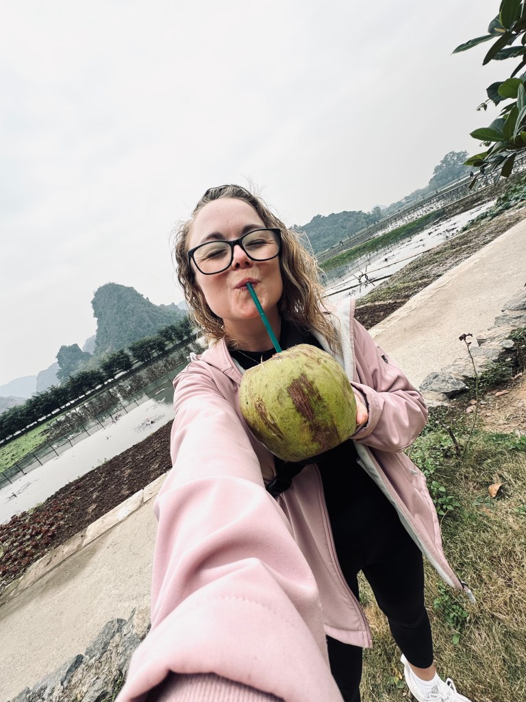 Girl drinking from fresh coconut in Ninh Binh, Vietnam
