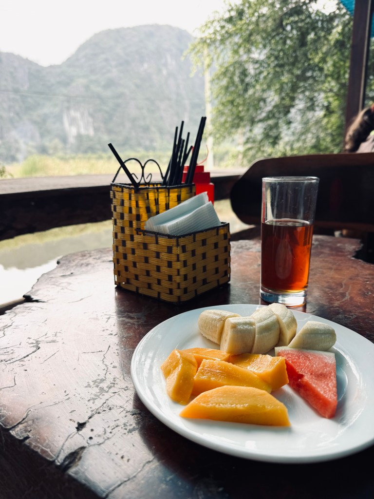 Breakfast plate of fresh fruit with mountain views at a homestay in Ninh Binh, Vietnam