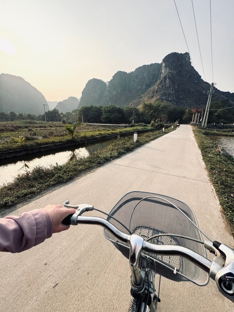 Bicycle at sunset riding through rice fields and mountains in Ninh Binh, Vietnam