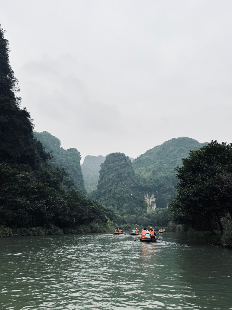 Trang An boat ride with mountains in background in Ninh Binh, Vietnam