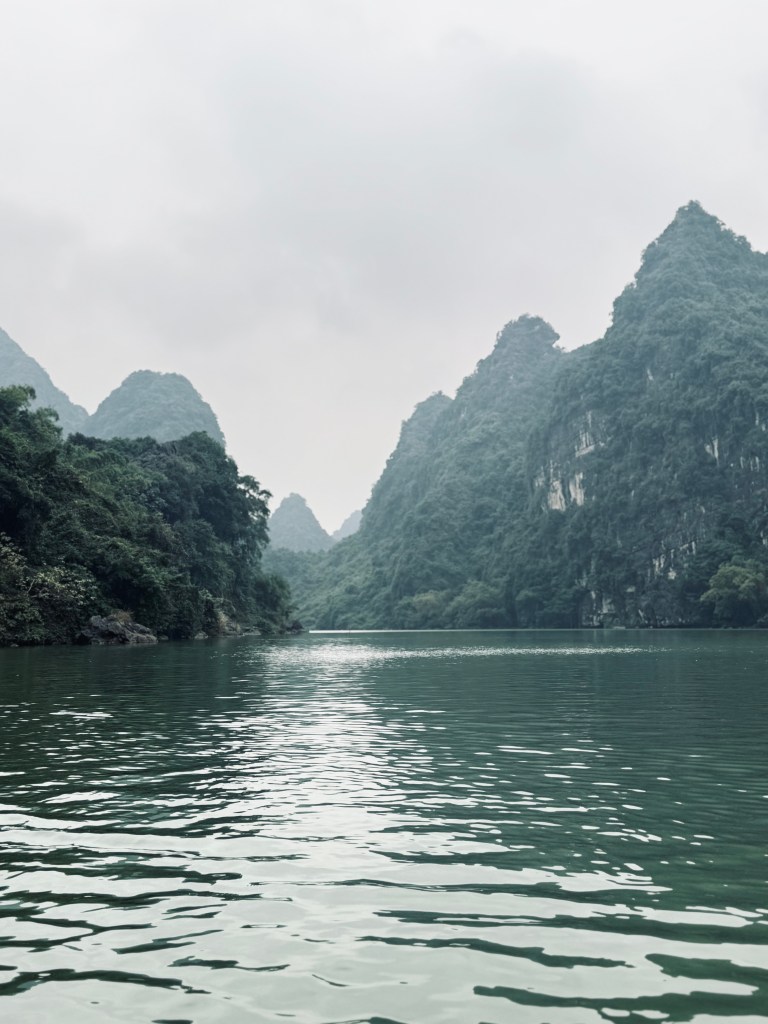Trang An boat ride with mountains in background in Ninh Binh, Vietnam