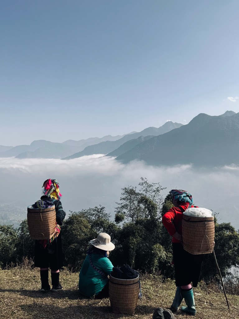 Local ladies looking out at mountain views on a trekking tour in Sapa, Vietnam