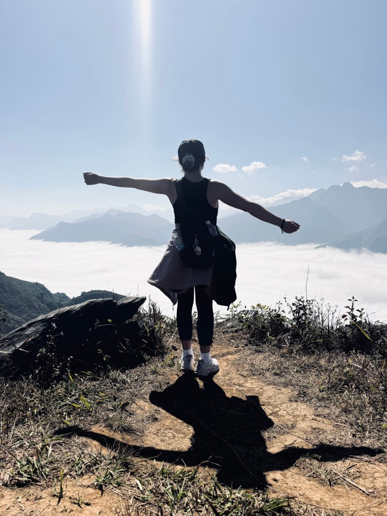 Girl posing with mountains in background on a trekking tour in Sapa, Vietnam